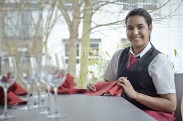 Image: Apprentice at the BFW Hotel Nuremberg folding napkins.